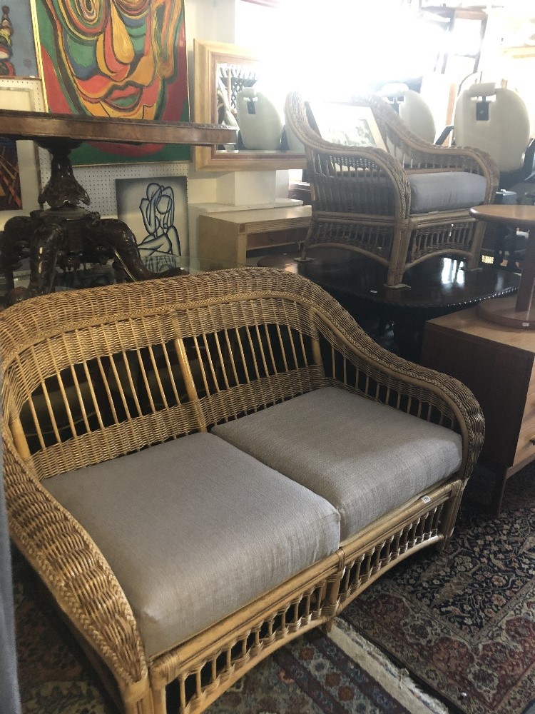 A wicker two seater sofa and arm chair