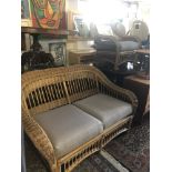 A wicker two seater sofa and arm chair