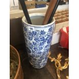 A blue and white umbrella stand with three walking sticks