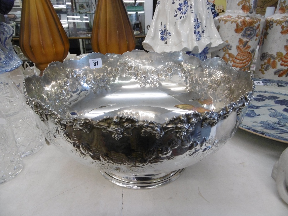 A large silver plated punch bowl with lion head handles