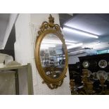 An oval gilt mirror