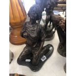 A bronze sculpture of a kneeling lady