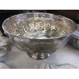 A large silver plated punch bowl with fruit decoration