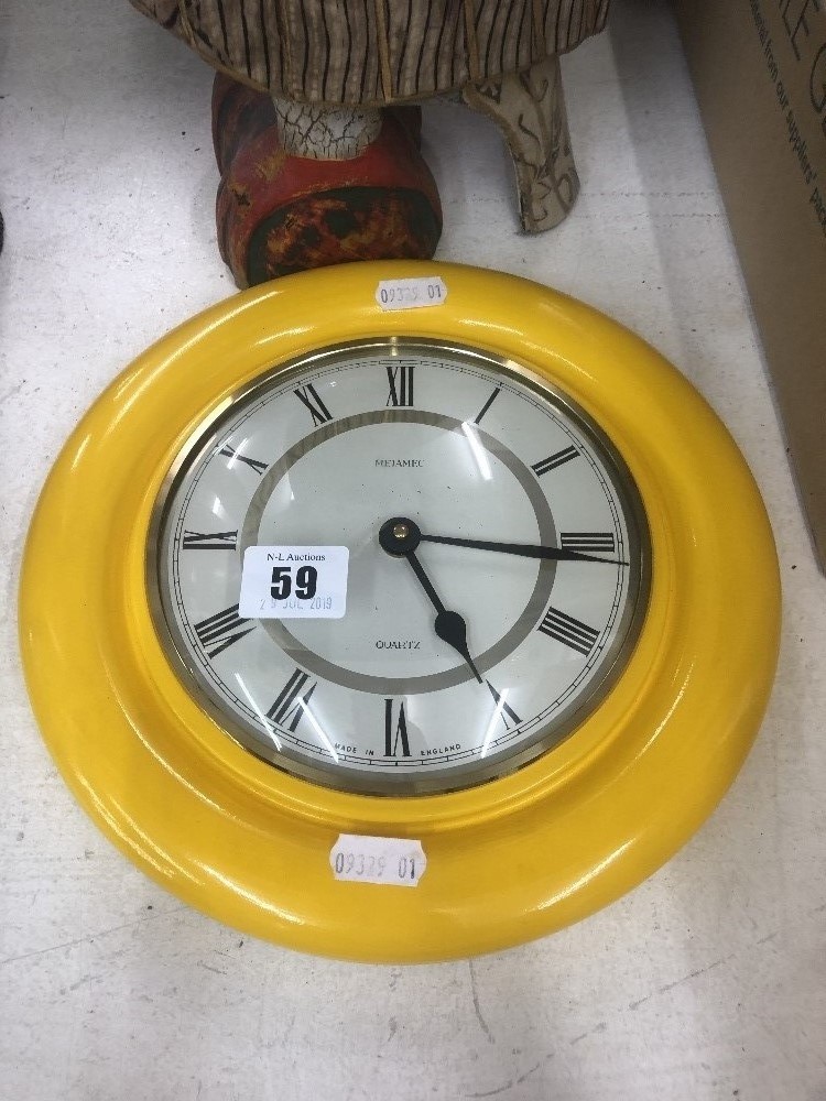 A yellow Metamec wall clock