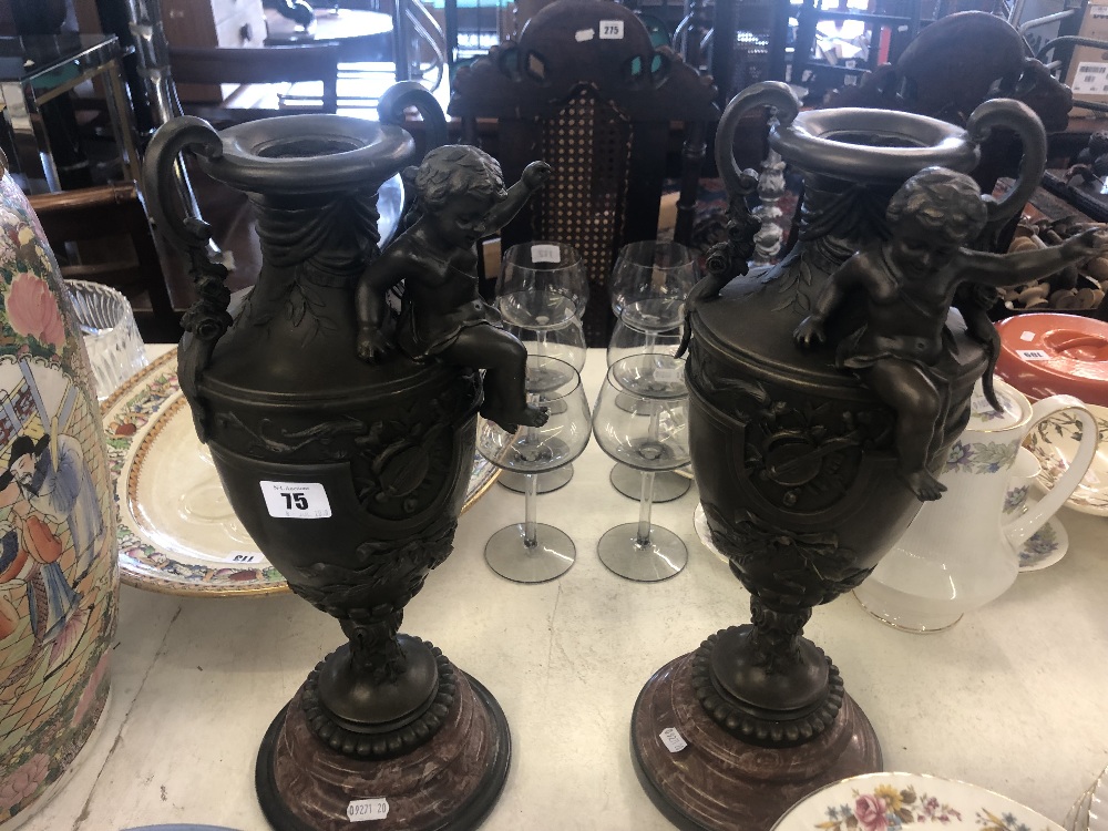 A pair of bronze cherub vases