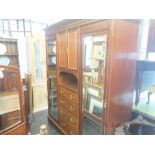 An Edwardian mahogany triple mirror fronted wardrobe