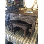 A carved oriental desk and side table