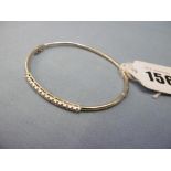 A 9ct gold bangle set with .