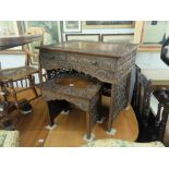 A carved oriental desk and side table