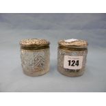 A pair of cut glass hallmarked silver lidded vanity jars