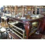 A mahogany extending dining table with a leaf and winder