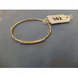 A 9ct gold bangle set with .