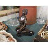 A bronze sculpture of a kneeling lady