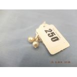 A pair of white pearl earrings with diamond centres