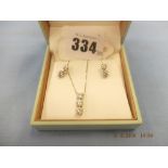 A pair of 18ct white gold and diamond earrings plus a matching pendant on white gold chain (9ct