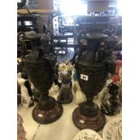 A pair of bronze cherub vases
