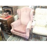A pink upholstered library chair