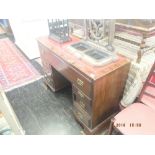 A mahogany pedestal desk with red leather insert