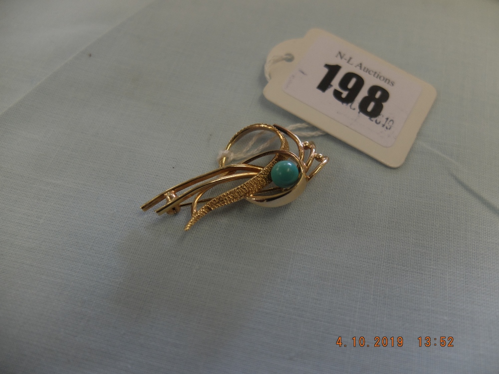 A yellow metal and turquoise brooch indistinctly marked