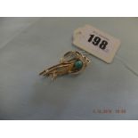 A yellow metal and turquoise brooch indistinctly marked