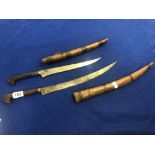 Two Moroccan flysse daggers with brass inlaid blades and carved wooden sheaf's