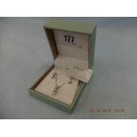 A pair of 18ct white gold and diamond earrings plus a matching pendant on white gold chain (9ct