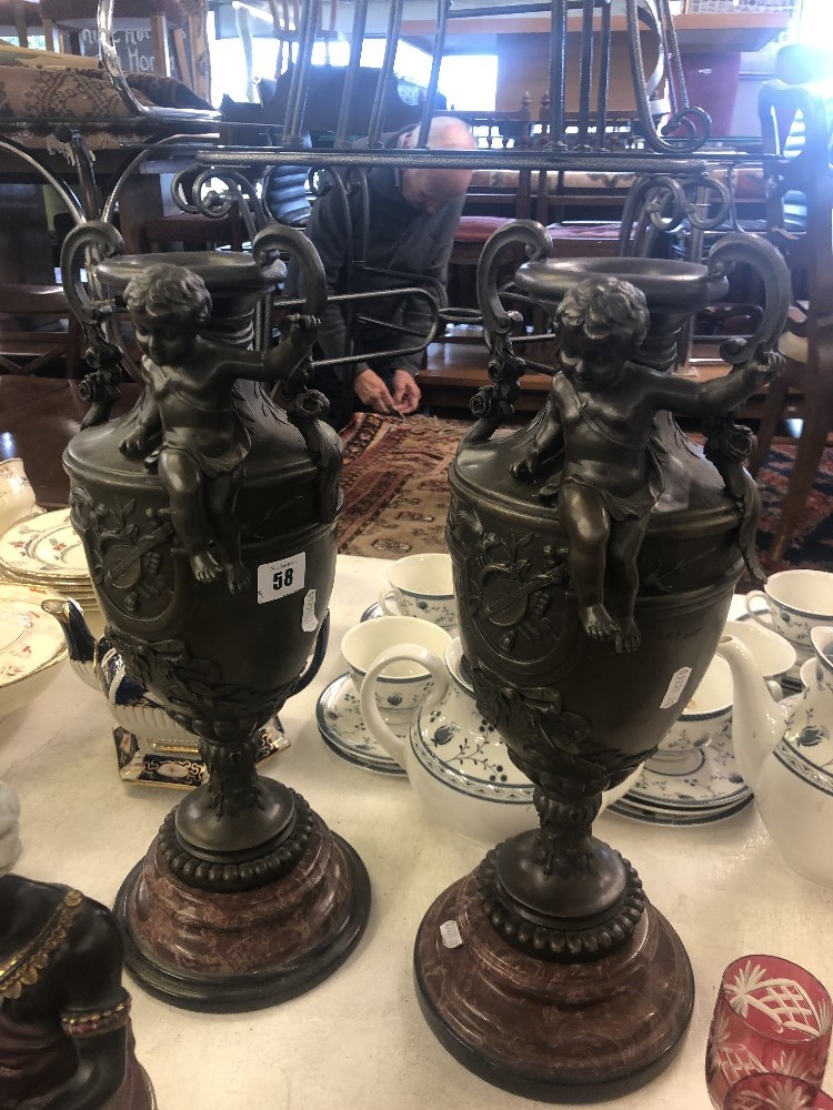 A pair of bronze cherub vases