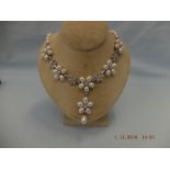 An 18ct white gold pearl and diamond necklace with a pearl and diamond floral drop pendant