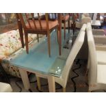 A glass extending dining table and eight cream back chairs