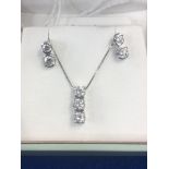 A pair of 18ct white gold and diamond earrings plus a matching pendant on white gold chain (9ct