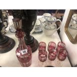 A cranberry glass decanter and six glasses