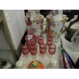 A cranberry glass decanter and six glasses