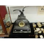 A French spelter clock on marble and black onyx base surmounted with eagle