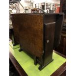 An oak drop leaf table with cupboard