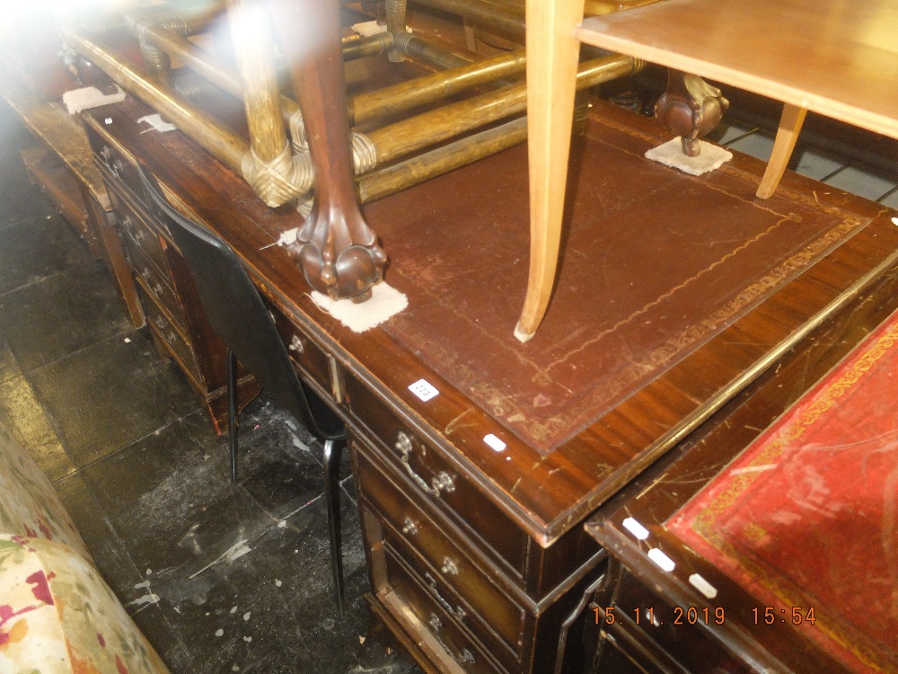 A large mahogany leather top pedestal desk