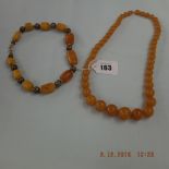 An amber and silver bead necklace and one other
