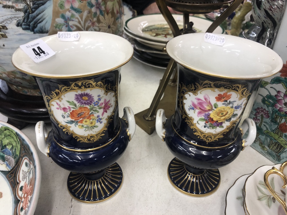 A pair of blue ground Dresden vases, hand painted with flowers,