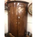 An early 19th century inlaid mahogany corner cupboard