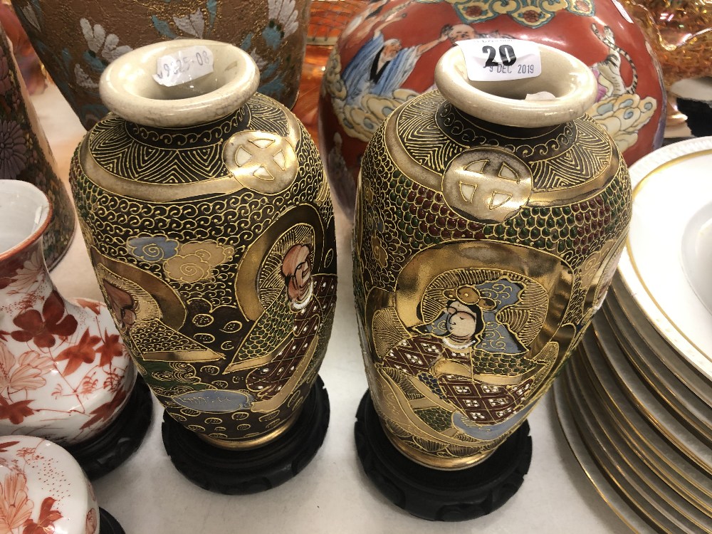 A pair of Satsuma vases on stands