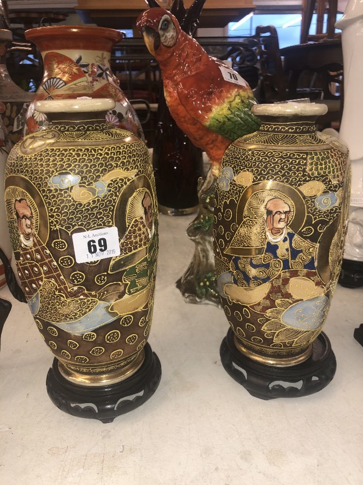 A pair of Satsuma vases on stands