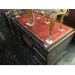 A pedestal desk red leather top