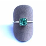 Bague or blanc centrée en clos d'une émeraude Colombie au vert profond et lumineux [...]