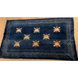 TAPIS CHINOIS Tapis à fond bleu à motifs de fleurs beige, entouré d'une double [...]