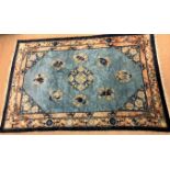 GRAND TAPIS CHINOIS En laine à fond bleu, à décor de chauves souris et de symboles [...]