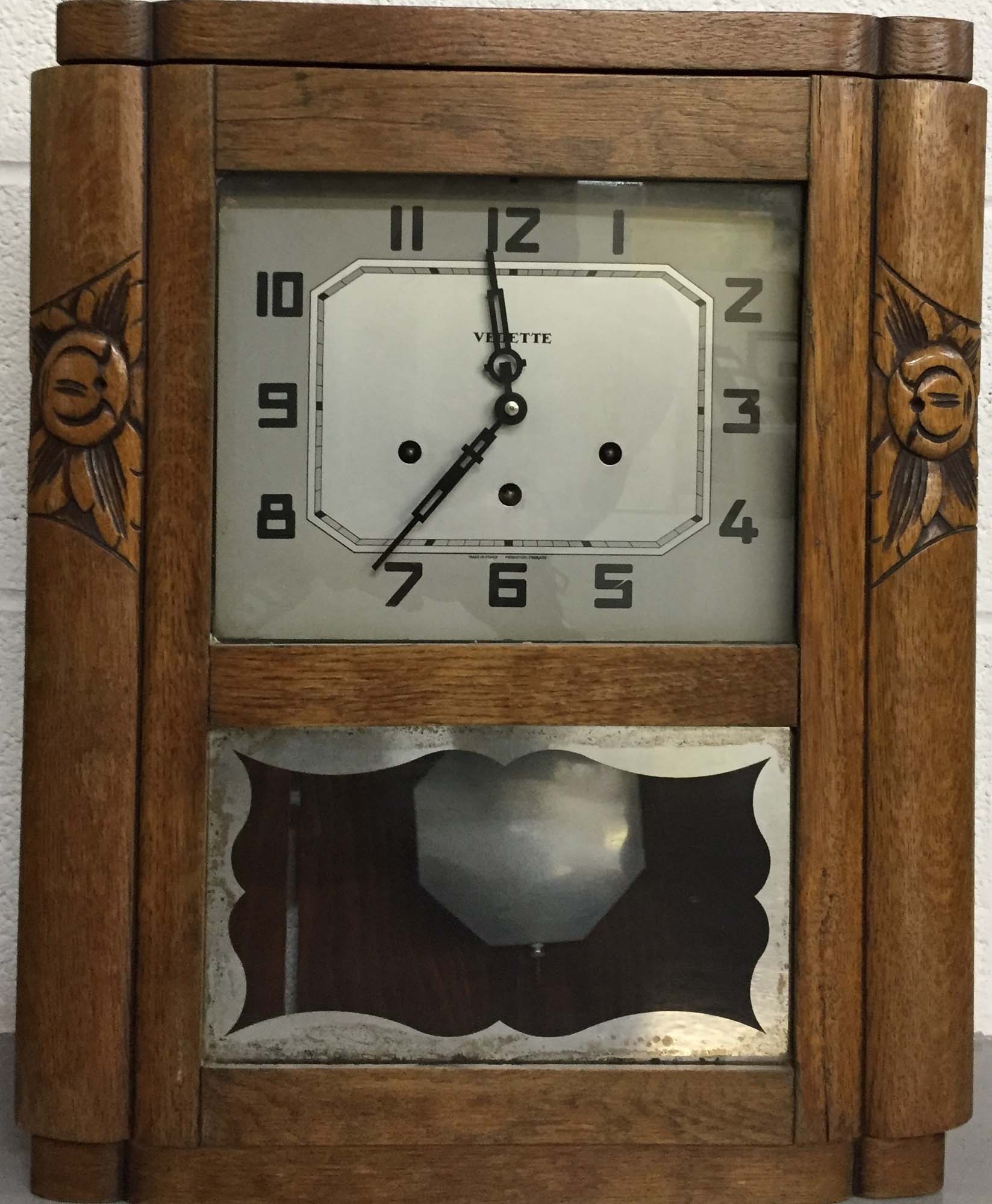 VEDETTE. A French Art-deco style Vedette pendulum clock with carved wooden casing.