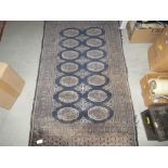 Antique rug with blue ground and multiple lozenge decoration 135 cms x 75 cms
