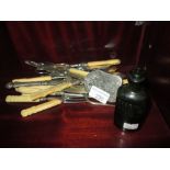 Bag of early 20th century silver plated cutlery & glass advertising bottle