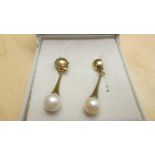 Pair of 9 ct gold teardrop shape earrings set with single cultured pearls in a Bennetts of Paignton