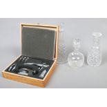 Three cut glass decanters, along with a cased chrome plated bottle opener set.