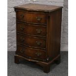 A miniature burr walnut chest of four serpentine drawers, cross banded in mahogany and raised on